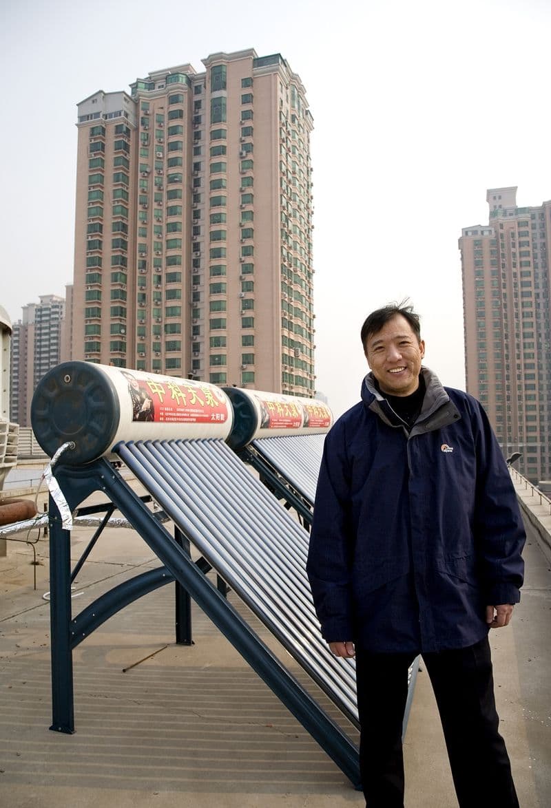 Ingeniør Guo Kang fra DNV GL viser frem solar water heater montert på taket av barneskole i Beijing. Foto: DNV GL