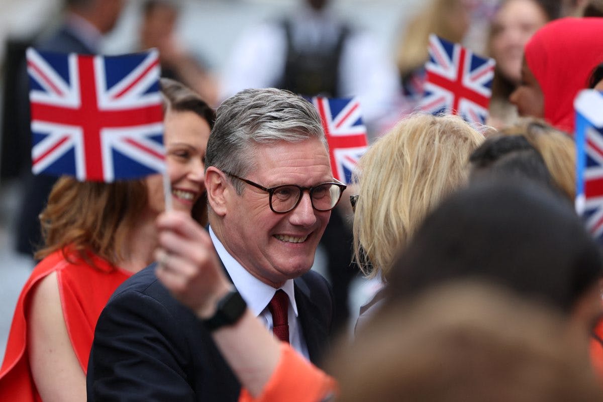 Labour-leder Keir Starmer smiler blant en mengde mennesker som holder Union Jack-flagg.