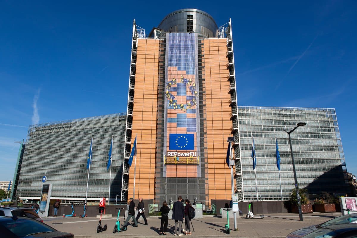 Europakommisjonens hovedkvarter i Brussel, med et sentralt tårn med et EU-banner og flagg. Noen få mennesker går i forgrunnen.