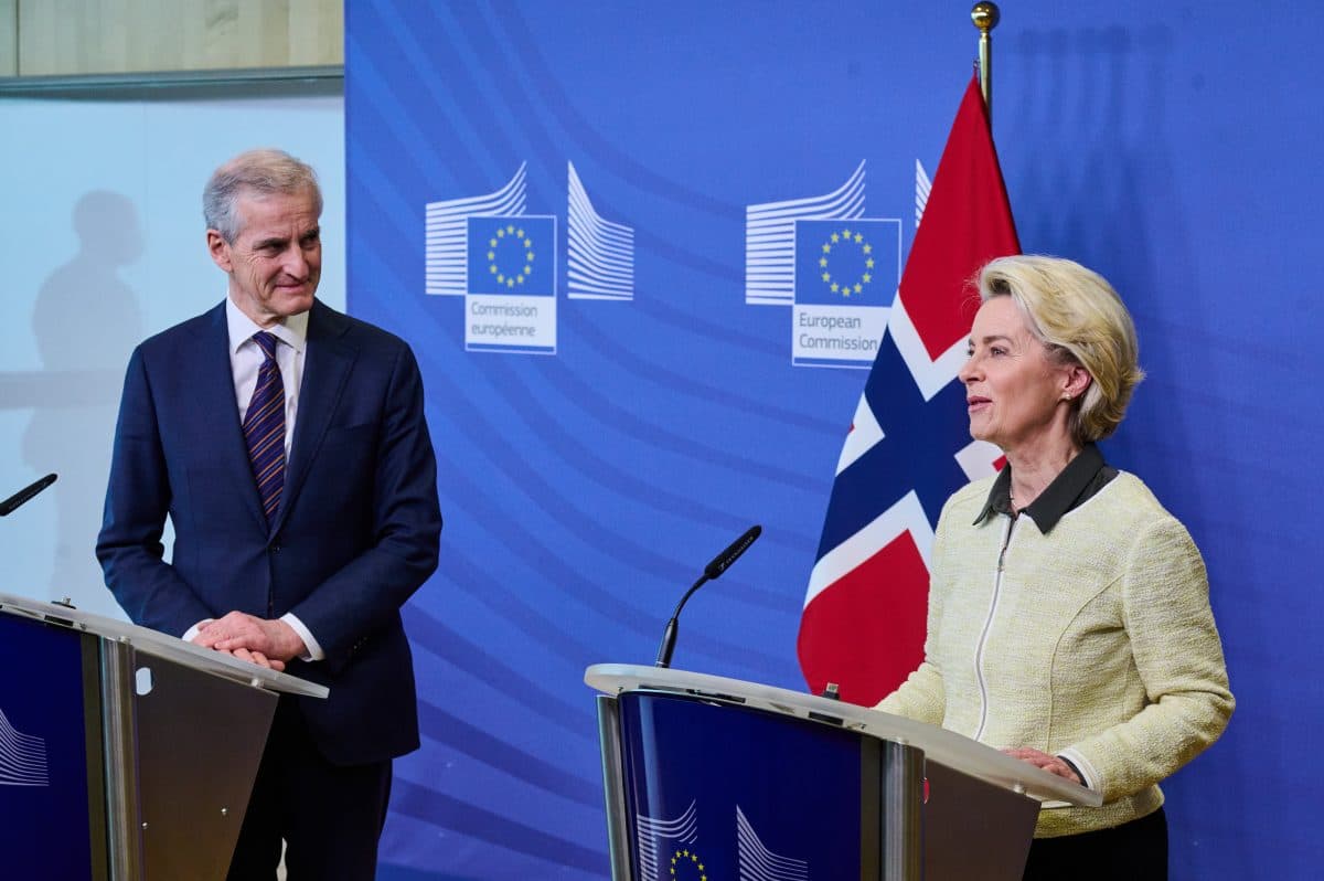 To personer står ved podier med EU- og norske flagg i bakgrunnen under en pressekonferanse.