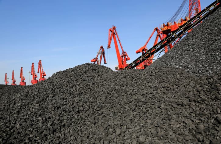 Cranes unload coal from a cargo ship at a port in Lianyungang