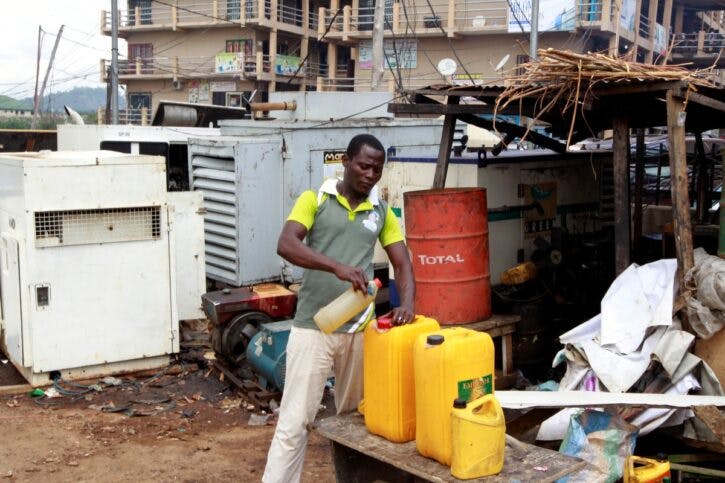A man seen pouring diesel into a container next to power generators at the Area 10 shopping centre in Abuja
