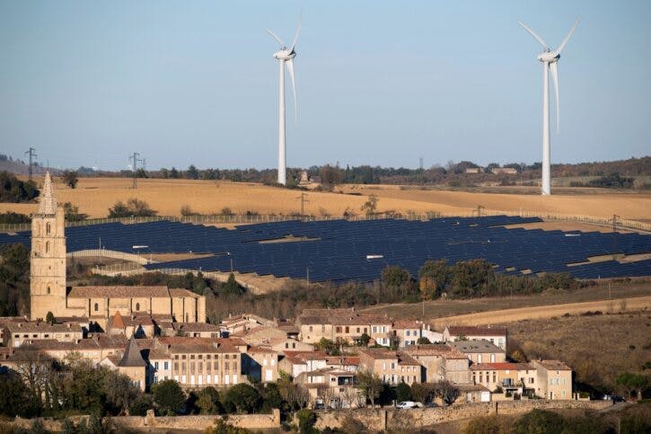 General view shows wind turbines behind rows of solar panels in Avignonet-Lauragais, in the Midi-Pyrenees region