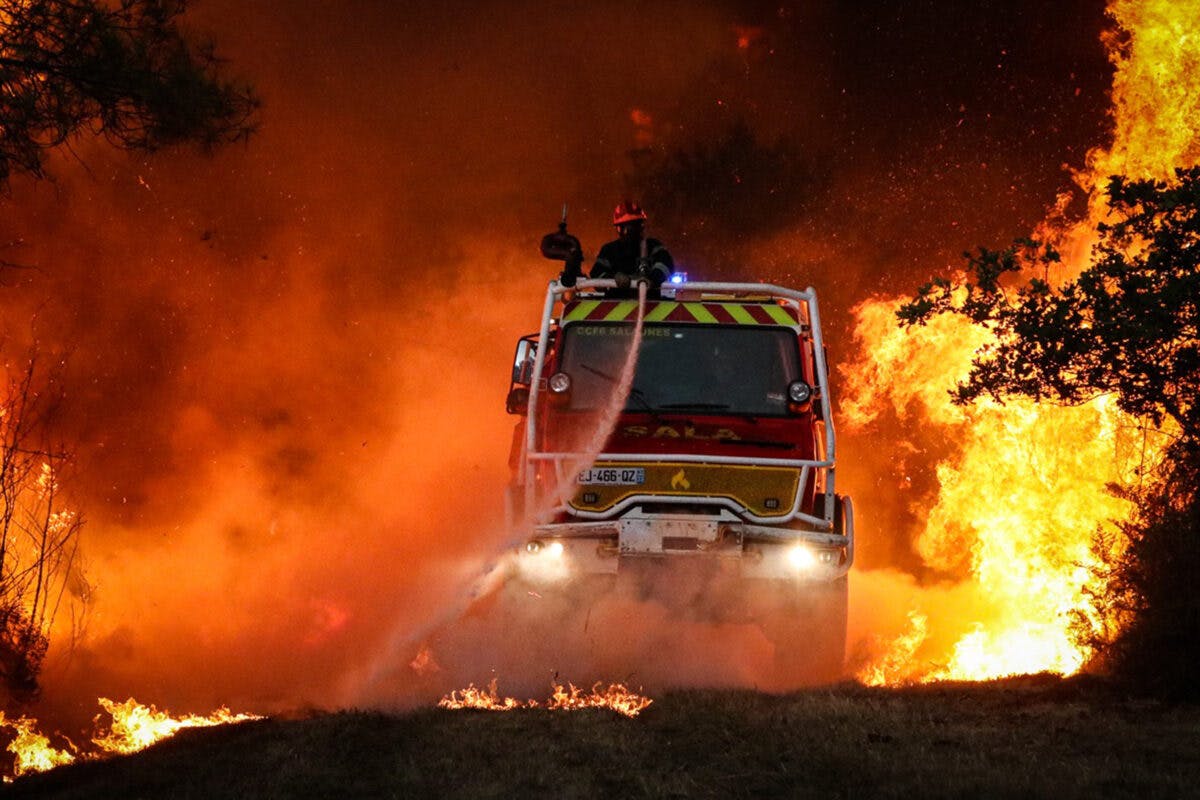 Mannskaper i brannbil jobber med å slukke skogbrann