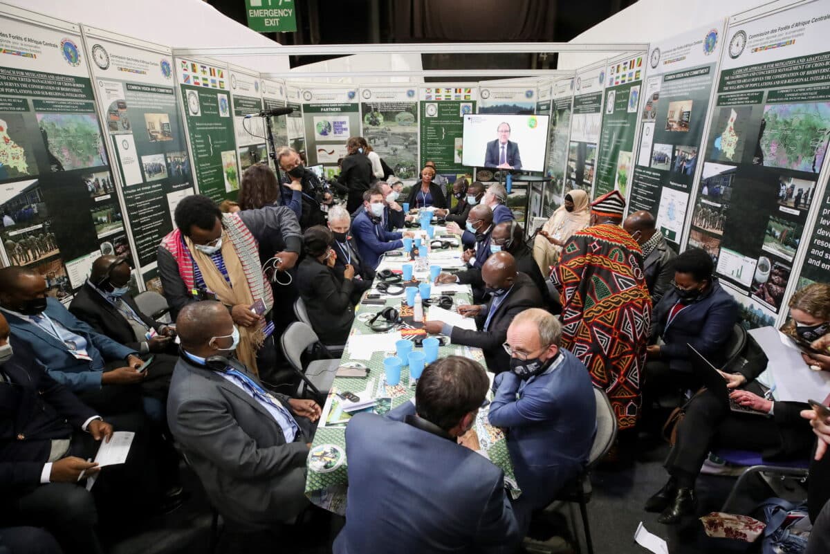 En stor gruppe delegater tett samlet rundt møtebord