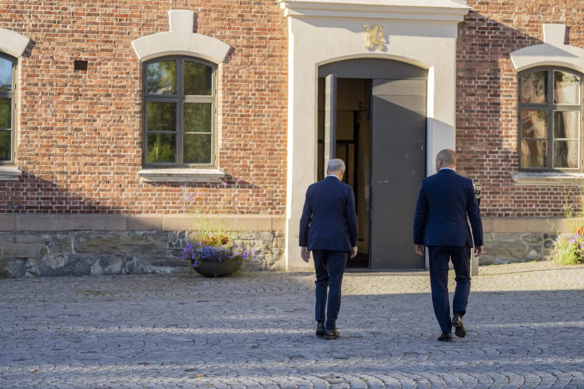 Støre og Vedum med ryggen til kamera