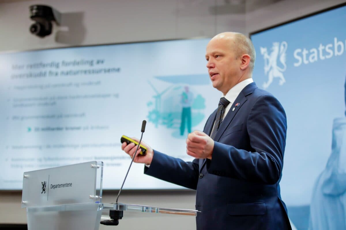 Vedum holder presentasjon, store skjermer i bakgrunnen