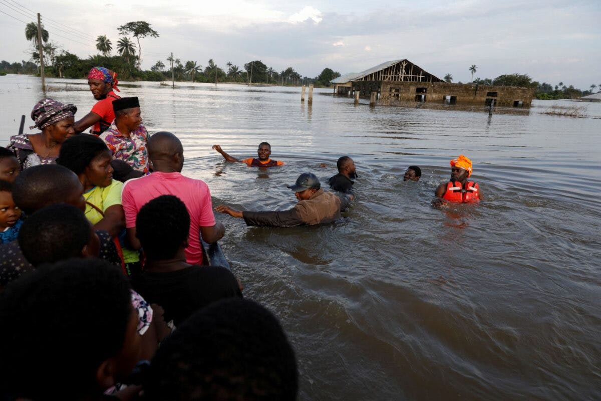 Flomrammede mennesker vassende i vann til halsen reddes opp i båt
