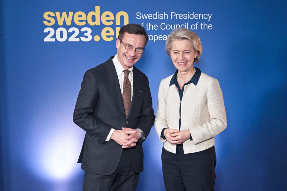 Ulf Kristersson og Ursula von der Leyen smilende foran blå bakgrunn.
