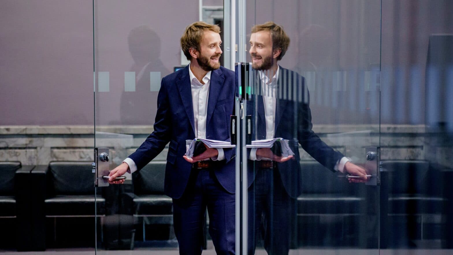 Jan Chr. Vestre åpner en glassdør og ser på sitt eget speilbilde.