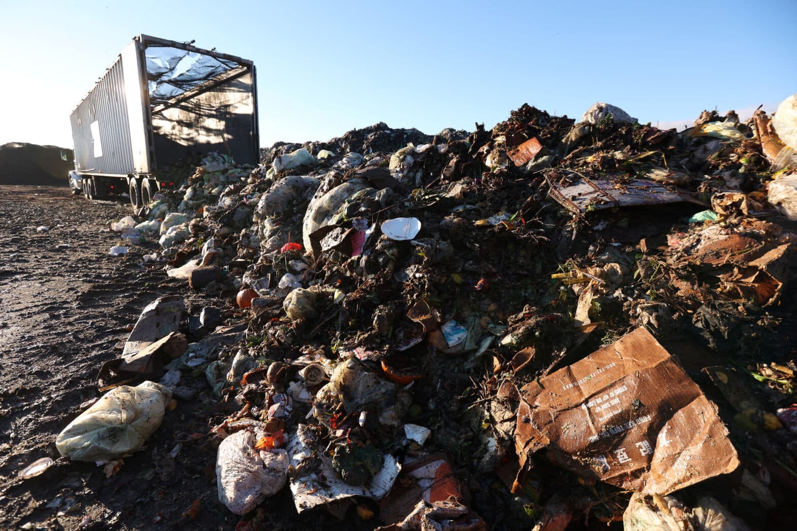Lastebil tømmer stort lass med matavfall ut på fylling.