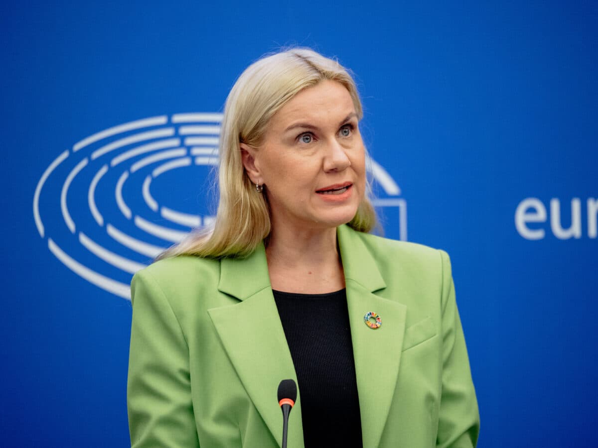 En kvinne i en grønn jakke står på et podium.