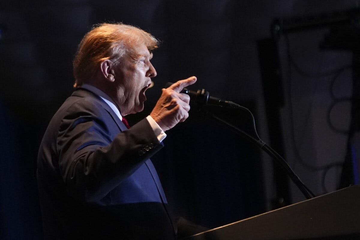 Donald Trump roper i en mikrofon med hevet pekefinger.