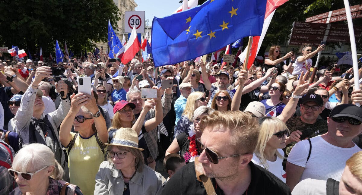 En mengde mennesker vifter med eu- og polske flagg.