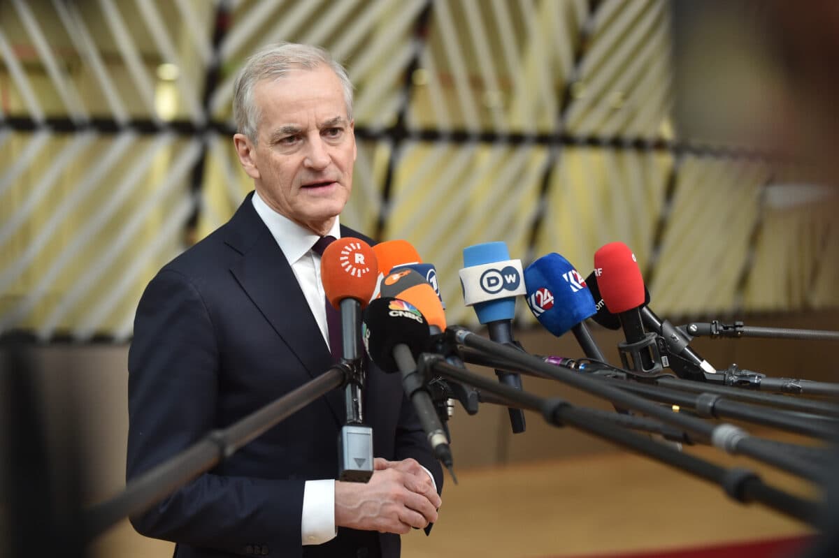 En mann snakker på en pressekonferanse med flere mikrofoner foran seg.