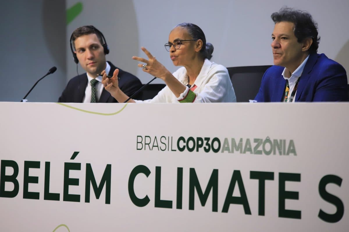 Tre paneldeltakere sitter bak et skilt for klimatoppmøtet i Belém på Brasil COP30 Amazônia-arrangementet; kvinnen i midten gestikulerer mens hun snakker.