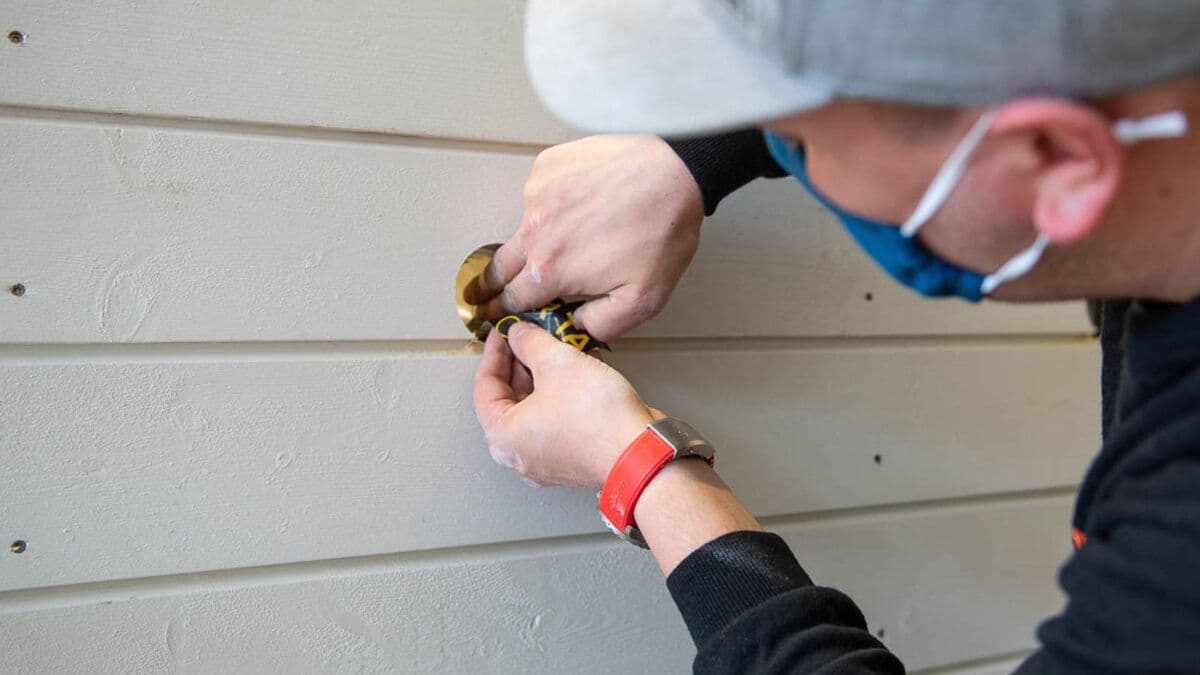 Håndverker arbeider med husvegg.