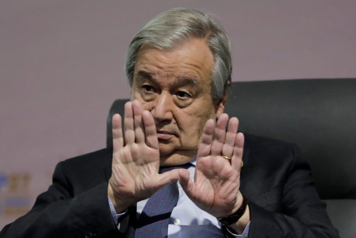 Antonio Guterres holder håndflatene opp foran ansiktet.